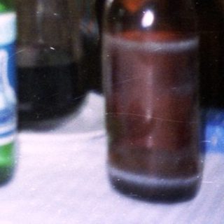 Three people seated at a table, gift exchange.