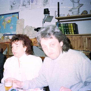 Three people seated at a table with decorations and books.