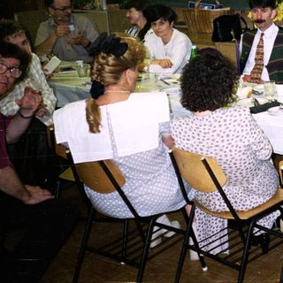 Group seated at a table in a room with a projector.