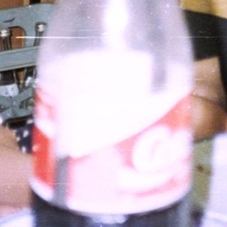 Three people sit at a table with food and drinks.