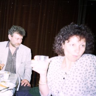 Two people seated at a table with drinks and food.