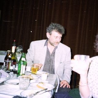 Two people seated at a table with drinks and food.