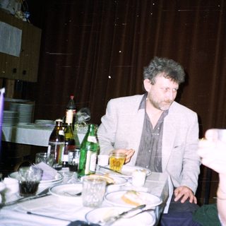 Two people seated at a table with drinks and food.
