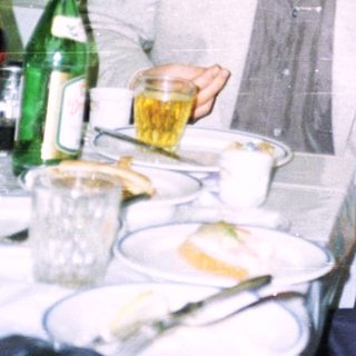 Two people seated at a table with drinks and food.