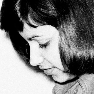 Woman in vintage clothing appears to be writing or drawing.