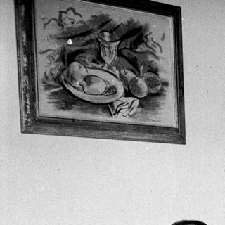 Man relaxes on a couch with drinks and artwork.