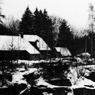 Winter landscape with a frozen lake and buildings.