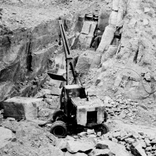 Quarry operation with stone extraction and machinery visible.