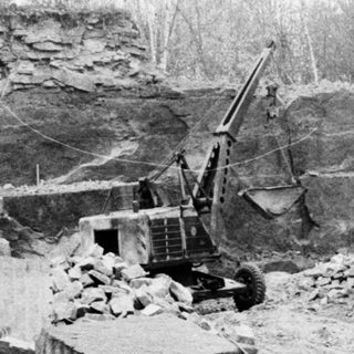 Quarry scene with stone blocks and machinery.