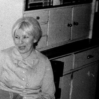Two women seated at a table in a kitchen.