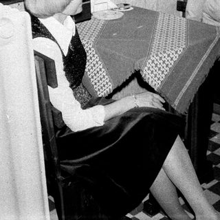 Two women seated at a table in a kitchen.