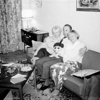 Couple seated on a sofa with a child's doll.