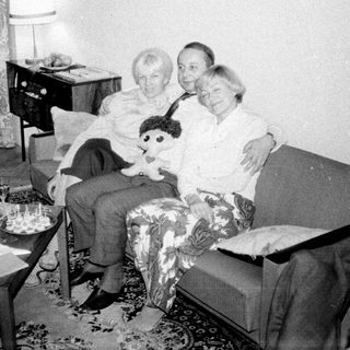 Couple seated on a sofa with a child's doll.