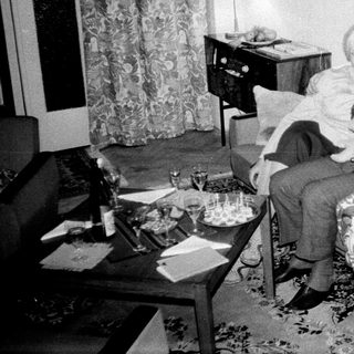 Couple seated on a sofa with a child's doll.