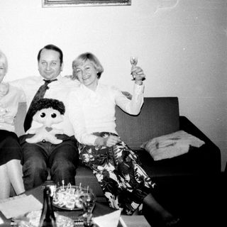 Couple and woman toasting on a sofa.