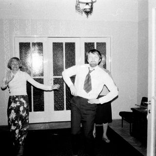 Couple stands in a hallway, appearing to dance.