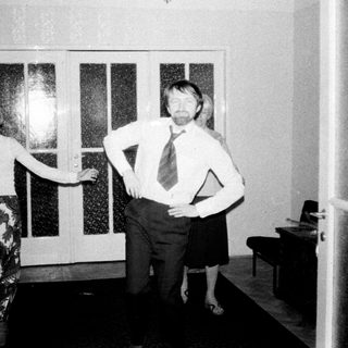 Couple stands in a hallway, appearing to dance.