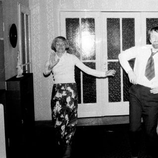 Couple stands in a hallway, appearing to dance.