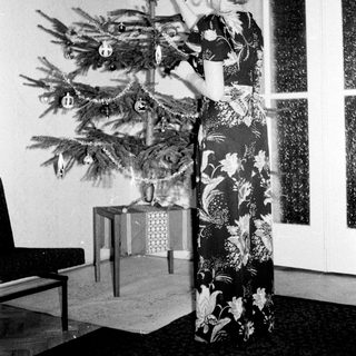 Woman decorates a Christmas tree in a vintage room.
