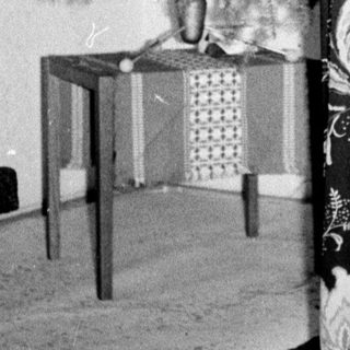 Woman decorates a Christmas tree in a vintage room.