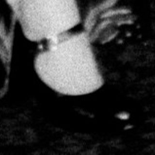 Woman sits under a small, decorated Christmas tree.
