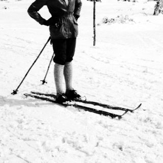 Man stands on skis in a snowy, wooded landscape.