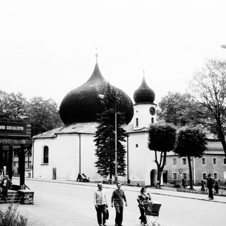 Black and white street scene with a domed church.