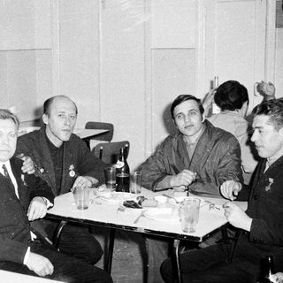 Men seated around a table in a restaurant setting.