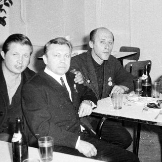 Men seated around a table in a restaurant setting.