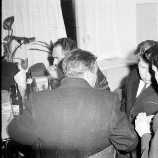 Group of men seated at a table, likely socializing.