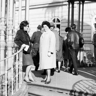 People on stairs outside a building in black and white.