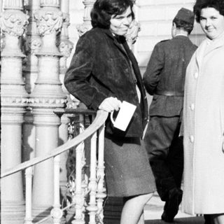 People on stairs outside a building in black and white.