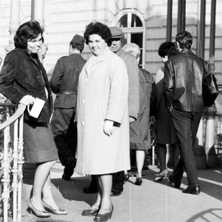 People on stairs outside a building in black and white.
