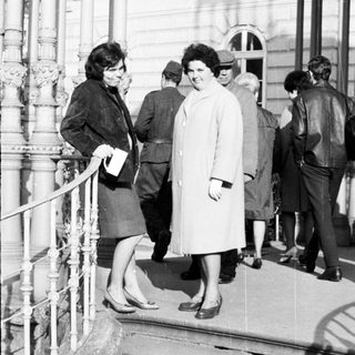 People on stairs outside a building in black and white.