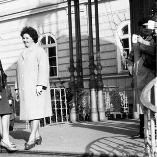 Two women in coats stand on a stone staircase.