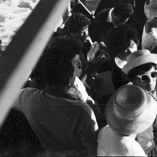 People crowded on a boat, peering over the railing.