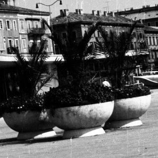 Black and white image of a public square with buildings.