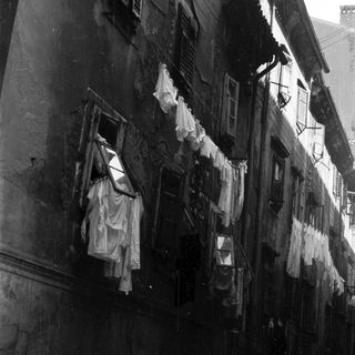 Black and white image of a building with laundry hanging.