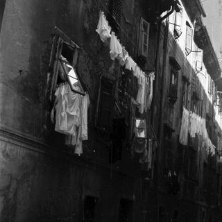 Black and white image of a building with laundry hanging.