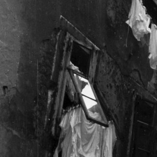 Black and white image of a building with laundry hanging.
