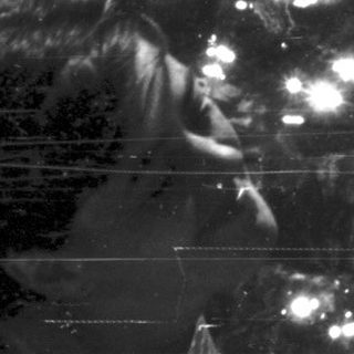 Person submerged underwater, surrounded by light and rocks.