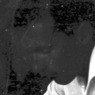Man seated at a table, possibly enjoying a drink.