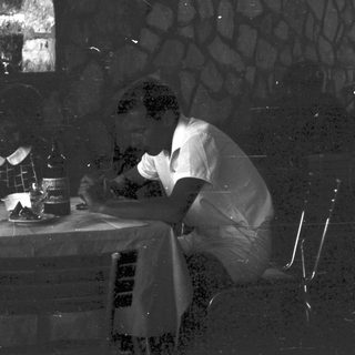 Man seated at a table, possibly enjoying a drink.