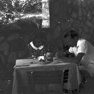Man seated at a table, possibly enjoying a drink.