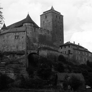 Black and white image of a castle on a rocky hill.