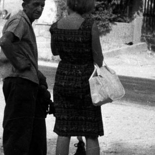 Man and woman conversing on a dusty road.