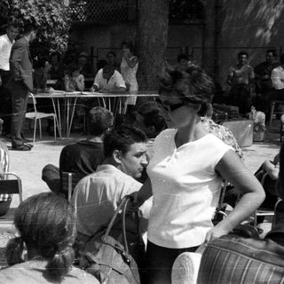 Group of people gathered outdoors with luggage.