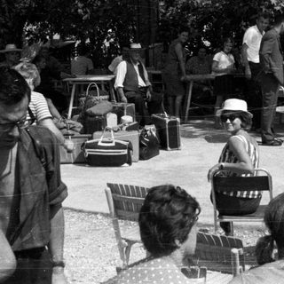 Group of people gathered outdoors with luggage.