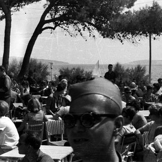 Group of people gathered outdoors near a body of water.