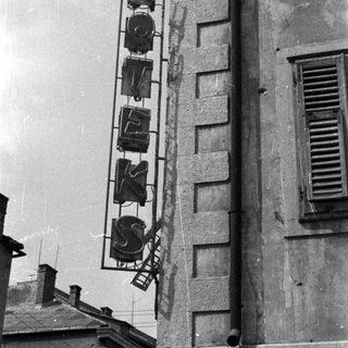 A neon sign is affixed to a building's facade.